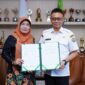 Wali Kota Pontianak Edi Rusdi Kamtono dan Rektor Universitas OSO Yarlina Yacoub memperlihatkan naskah MoU kerja sama kedua belah pihak.