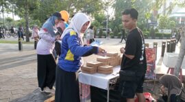 Petugas Sosialisasi Informasi, Kebijakan dan Akses Publik Pontianak (SIKAP) menyerahkan brosur program Pemkot Pontianak kepada masyarakat ketika CFD